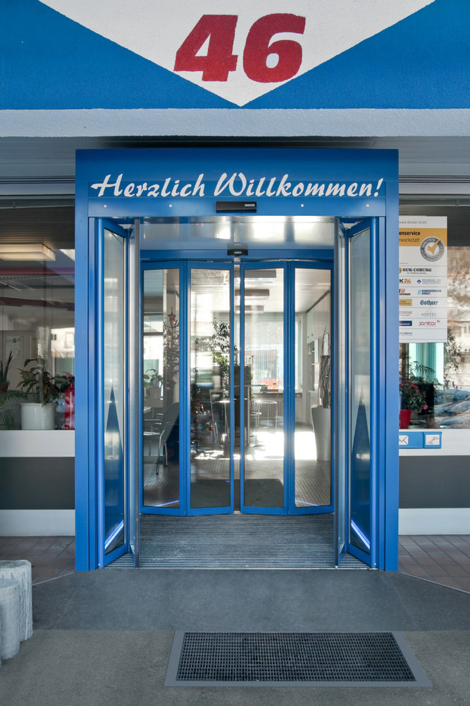 Eingang, Drehkreisel-Tür, blauer Rahmen, Glass-Türen, Willkommensschild